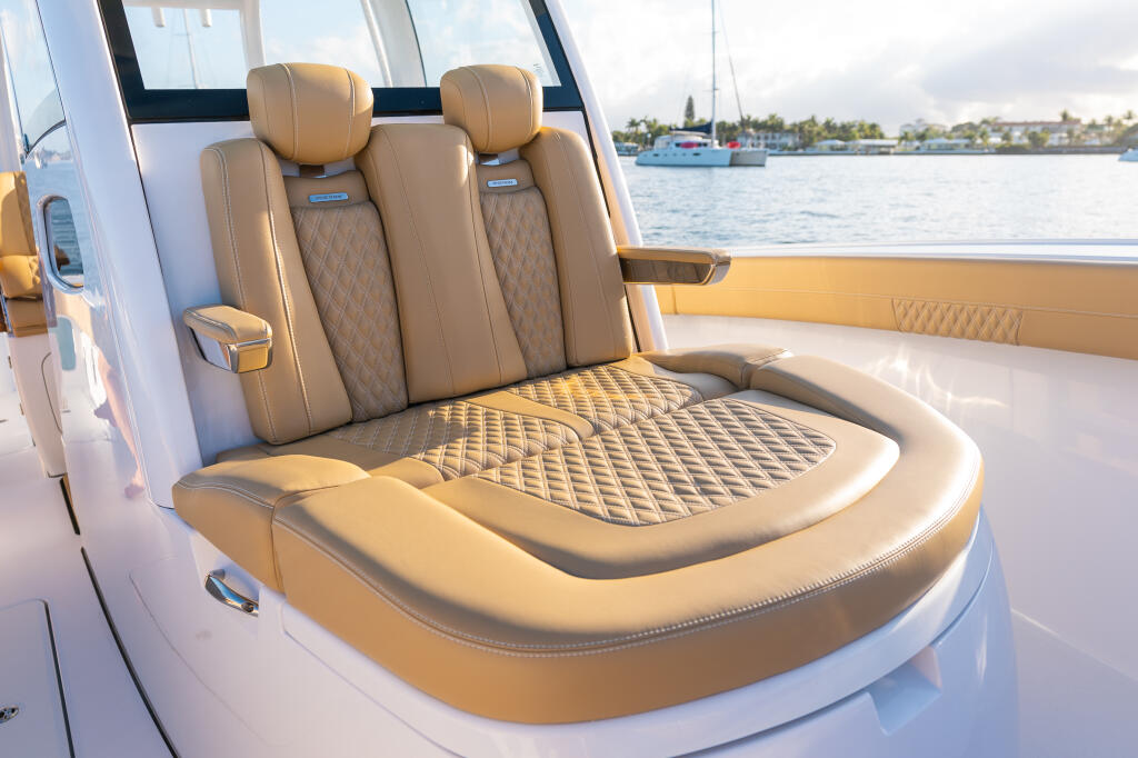 Luxurious tan leather helm seating with quilted details on a boat overlooking a marina