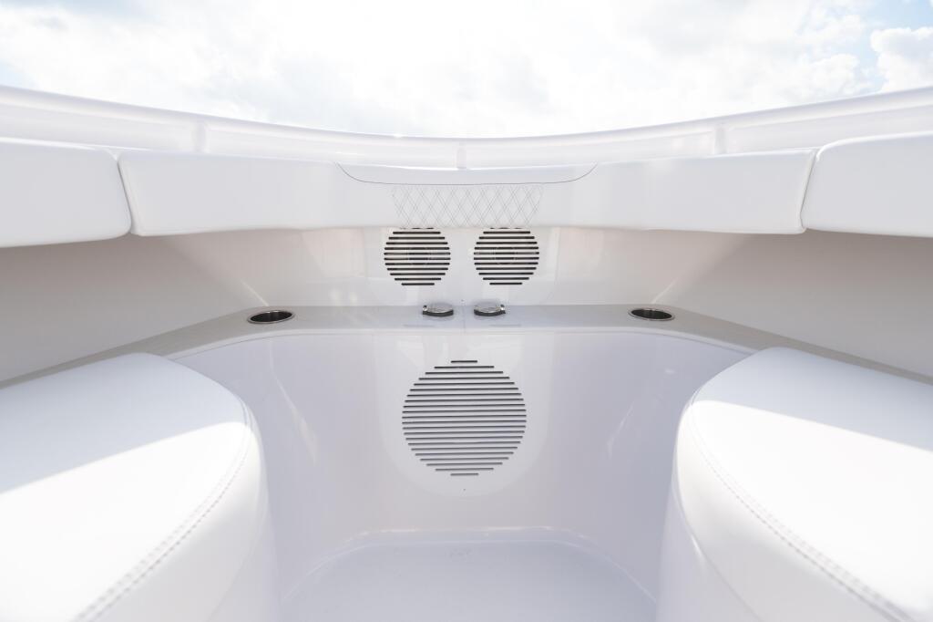 Cabin interior showing white seating, speakers, and audio system with skylight overhead
