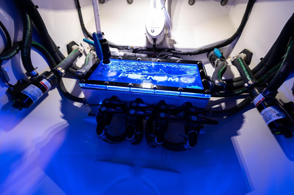 Overhead view of a blue boat thruster system with multiple hoses and control panel mounted on white deck