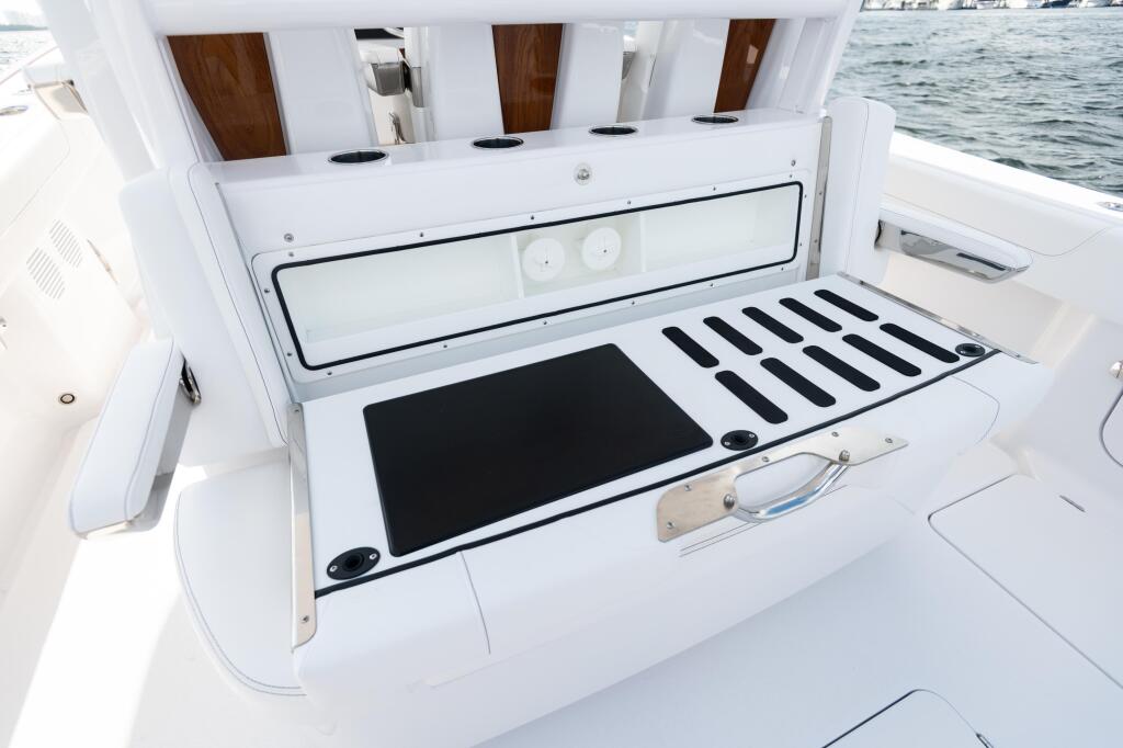 Open livewell with bait prep surface and rod storage slots on fishing boat deck