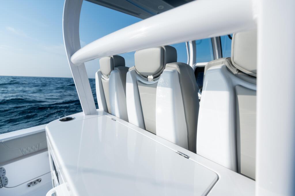 White leather helm seating with hard-top canopy overlooking open ocean