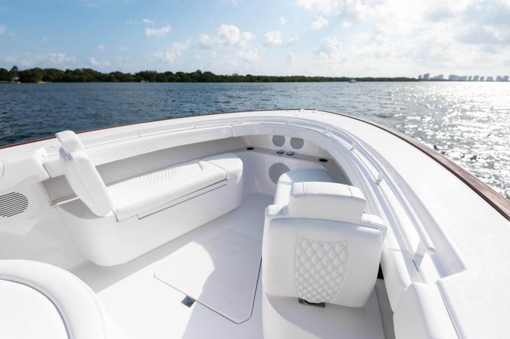Spacious white boat seating area with cushioned bolster seats and storage compartments overlooking open water