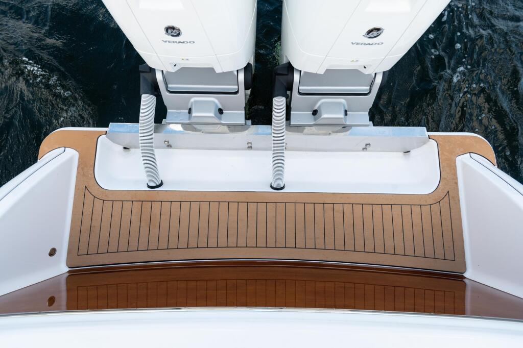 Overhead view of boat stern with dual outboard engines and teak swim platform