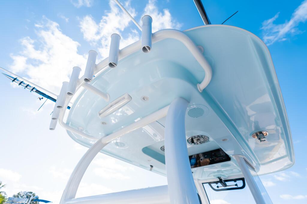 White fiberglass hard-top with tubular D-frame structure and grab rails viewed from below against blue sky