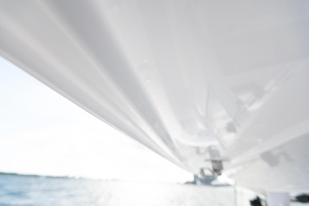 White canvas hard-top canopy stretched over a boat helm with water and horizon visible