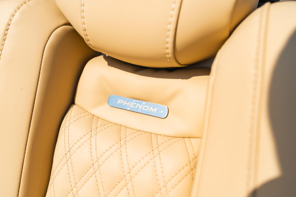 Cream-colored boat seat with quilted pattern and blue Phenom nameplate detail
