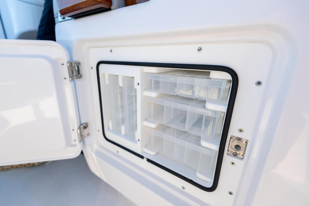 Open livewell compartment with transparent front door and organized storage shelves inside