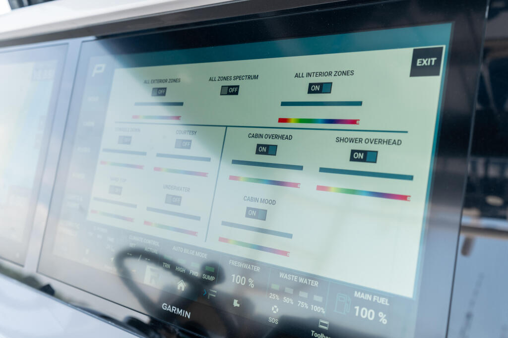 Marine electronics display showing lighting controls, cabin systems, and freshwater/waste water monitoring on a touchscreen