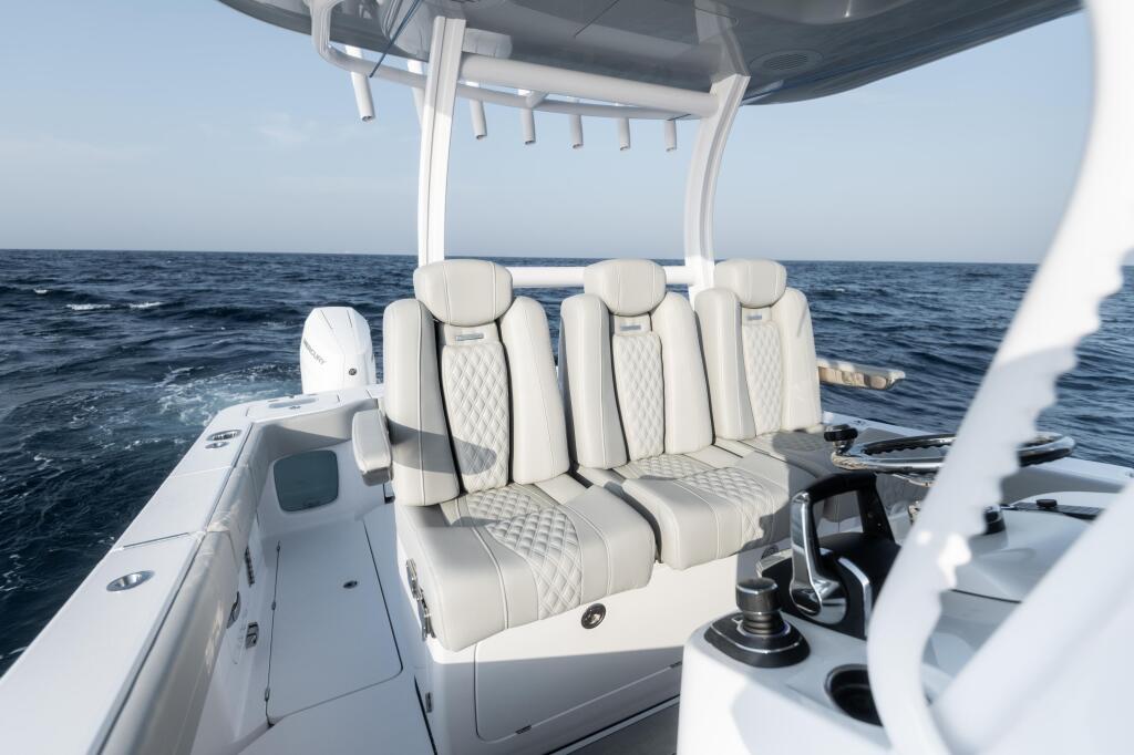 Cream-colored quilted captain's chairs under a hard-top canopy with ocean and sky in background