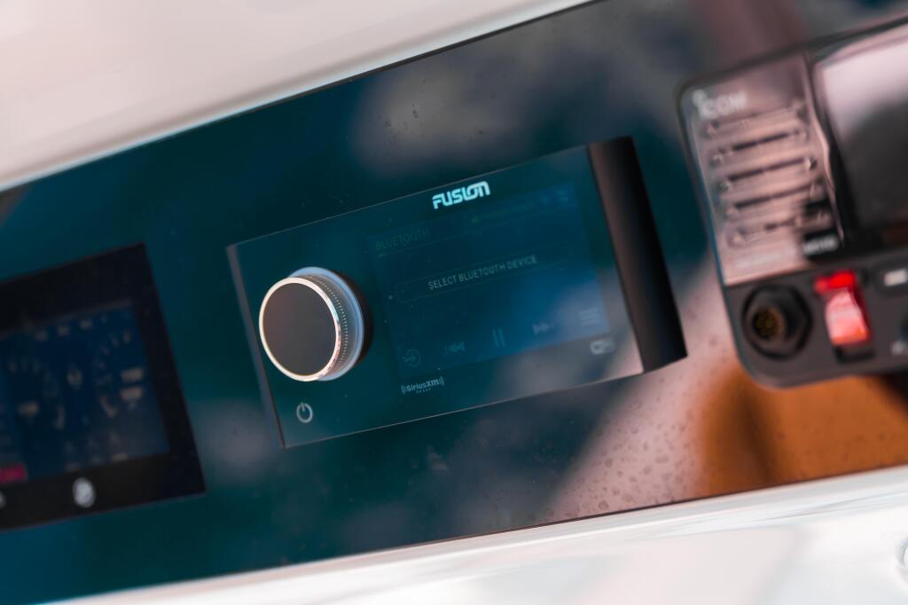 Fusion Apollo RA770 marine audio system with illuminated dial and Bluetooth interface on boat dashboard