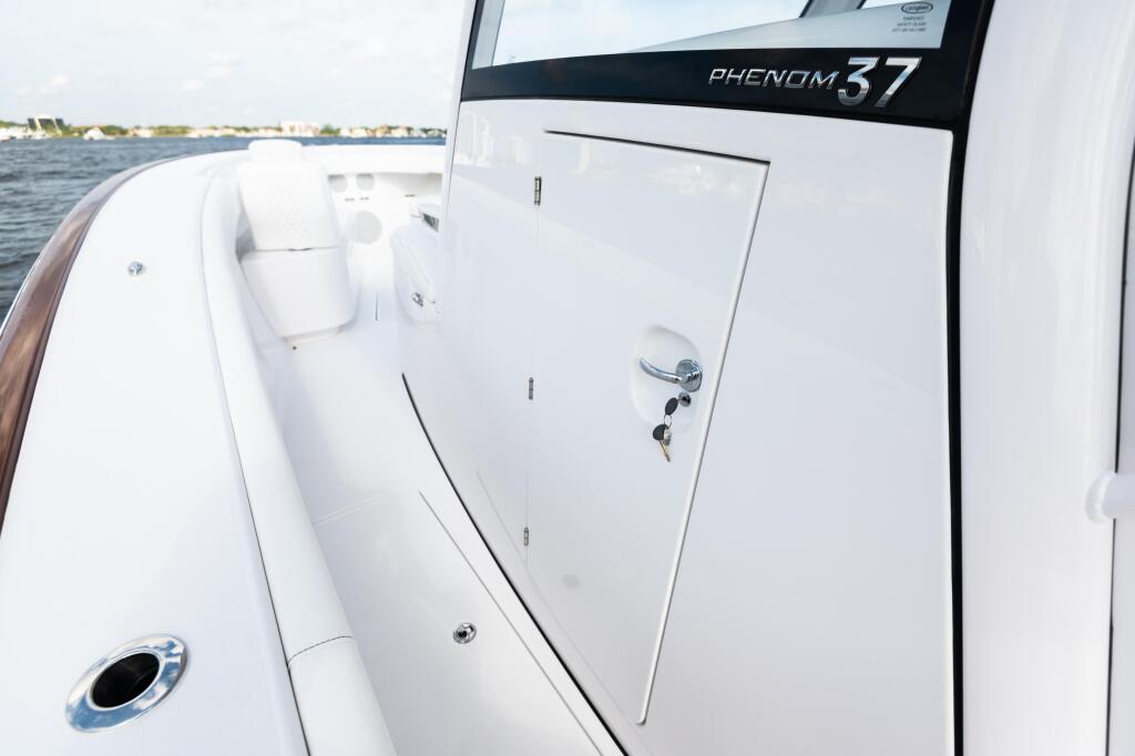 Phenom 37 cabin door and side detail showing white interior storage and hardware