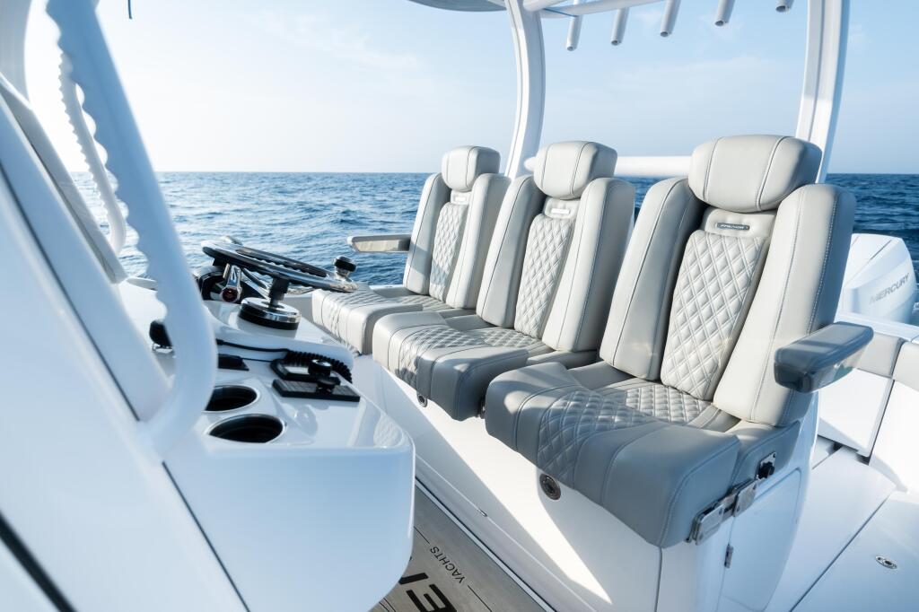 Luxury boat cabin with premium quilted seating for multiple passengers overlooking calm offshore waters