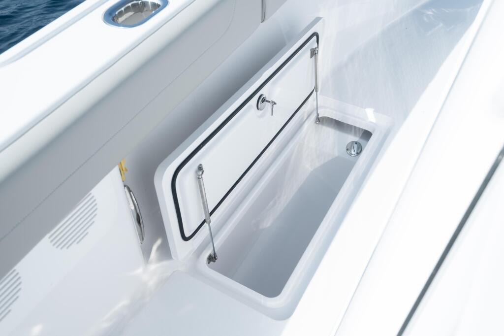 Open in-deck storage box with stainless steel handles and drain plug on boat gunwale