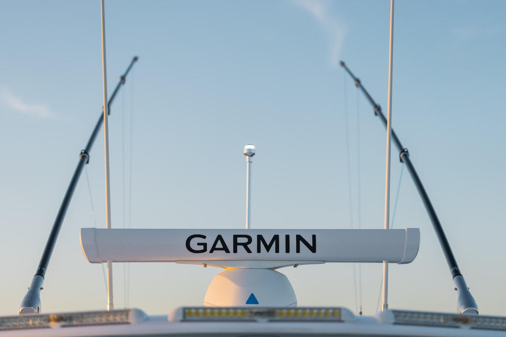 Garmin radar antenna mounted on boat's hard-top with mast and rigging visible against clear sky