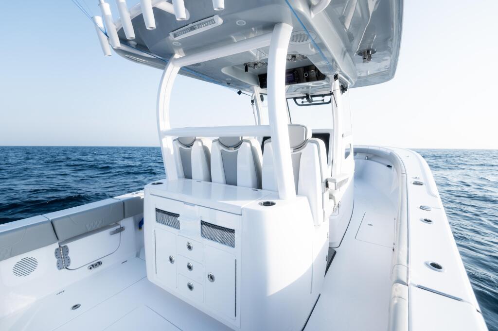 White center console boat with hard-top canopy and cushioned seating overlooking calm offshore waters