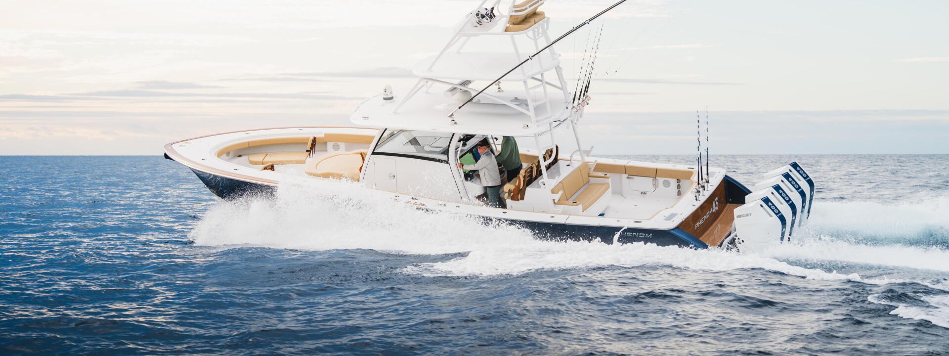 White fishing boat with extended outrigger running through waves in offshore blue waters