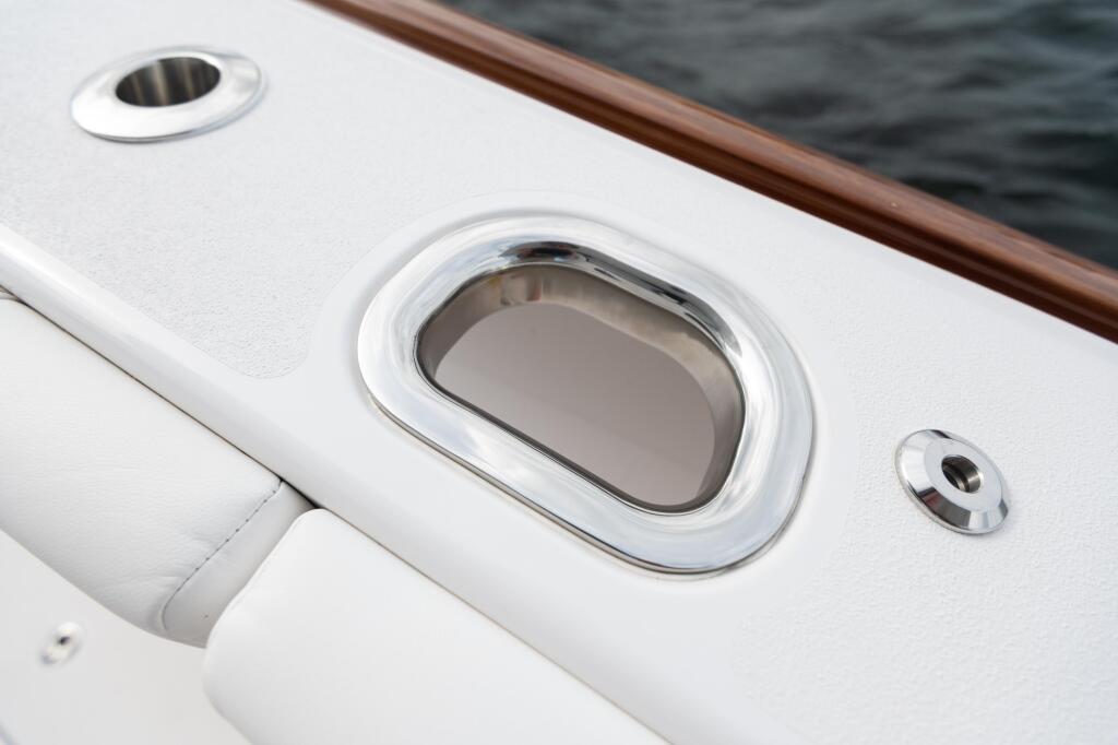 White boat cabin with polished chrome portlight window and ventilation fixtures