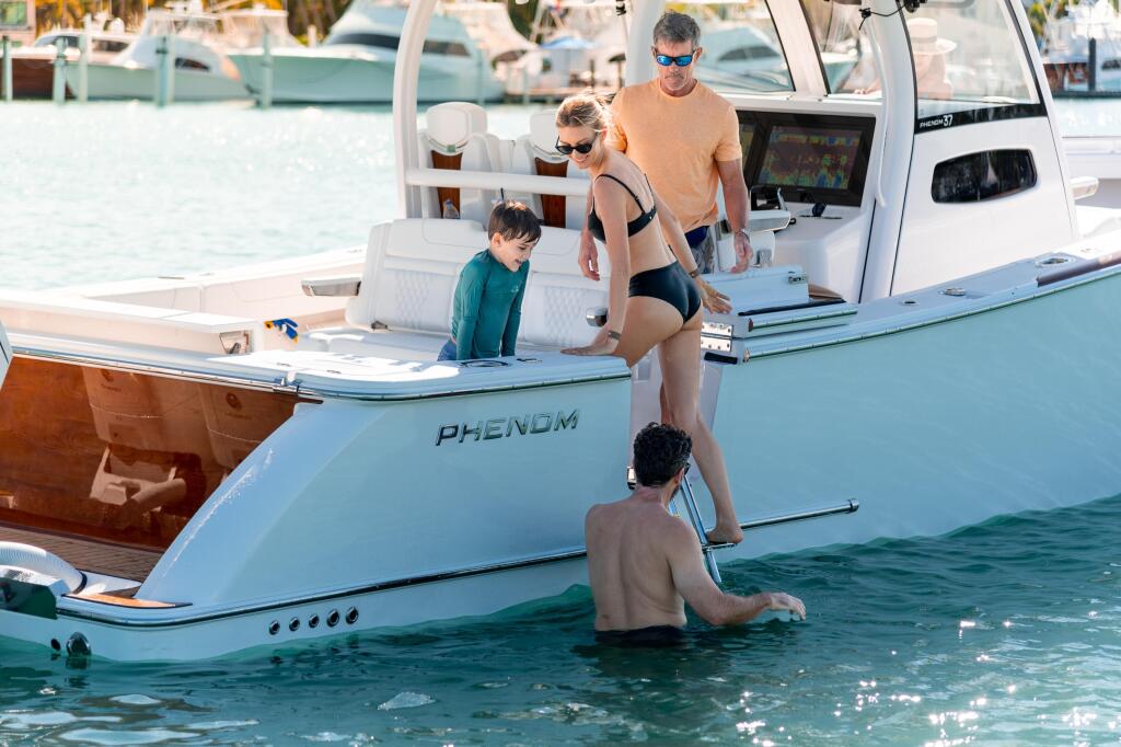 Family enjoying swimming and water activities from their moored boat at a tropical marina