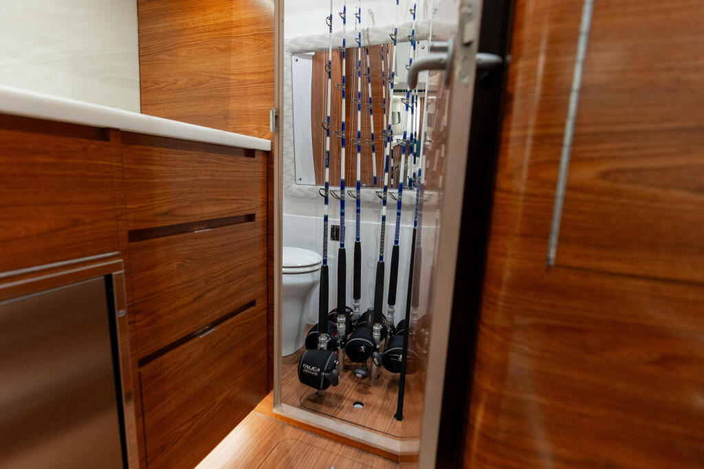 Fishing rod storage locker with organized rods and reels mounted vertically inside cabin