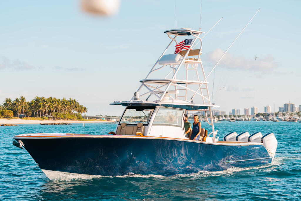 Sport fishing boat running in open water with hard-top, twin towers, and American flag flying