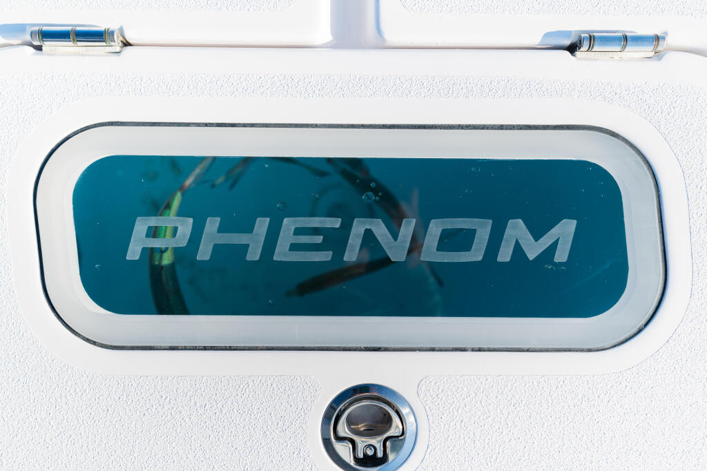 Phenom boat cabin window with blue tinted glass and chrome hardware mounted on white hull