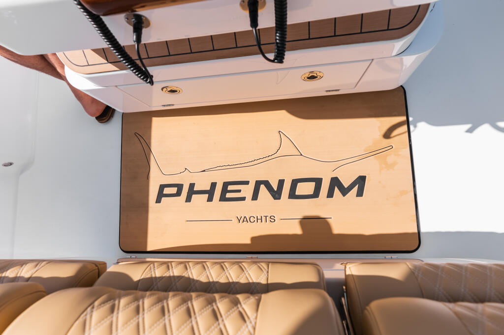 Phenom Yachts helm display screen mounted above tan leather seating with hardtop overhead