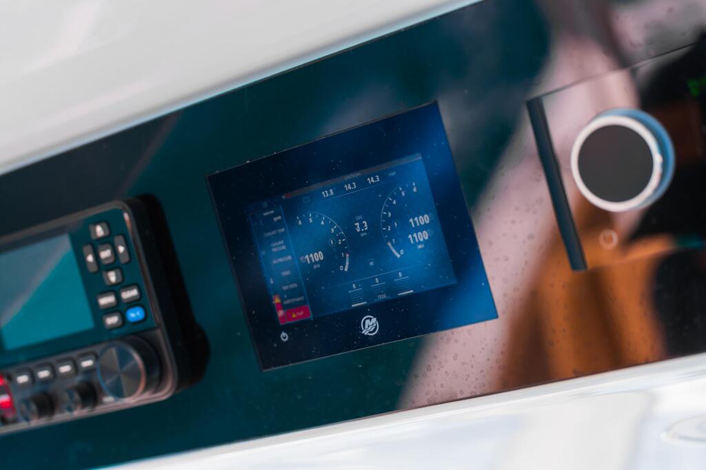 Digital display screen showing engine diagnostics and vessel data on a boat helm console