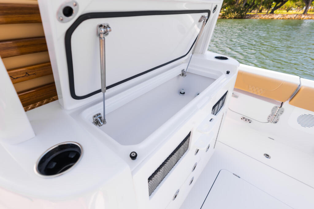 Open livewell with metallic rod and drain system built into white boat console