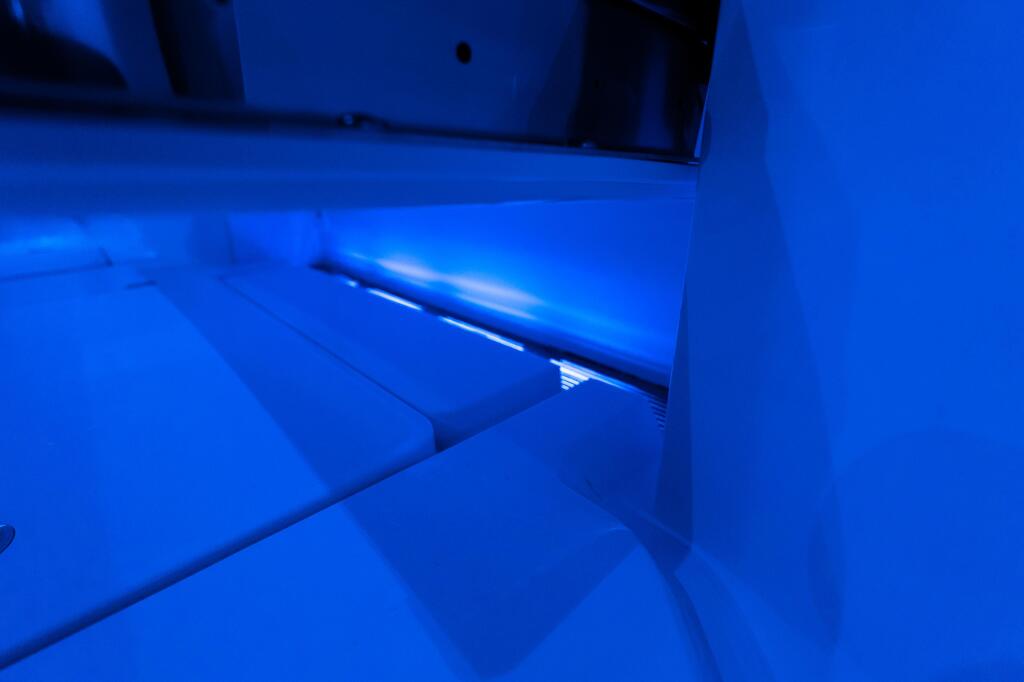 Close-up of boat cockpit floor with blue ambient lighting highlighting self-bailing design and seating area