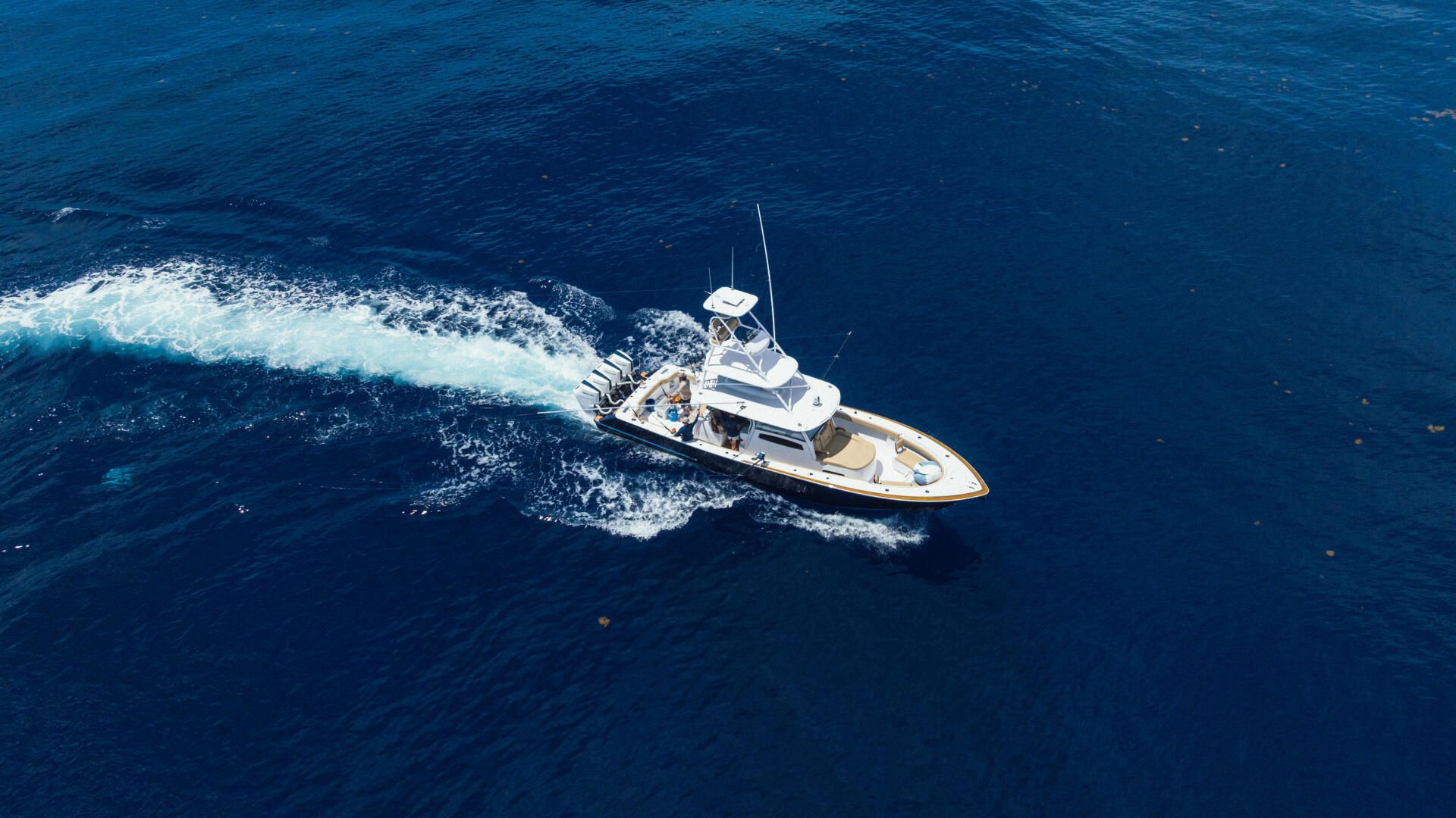 Sport fishing yacht cruising through blue ocean waters with visible wake
