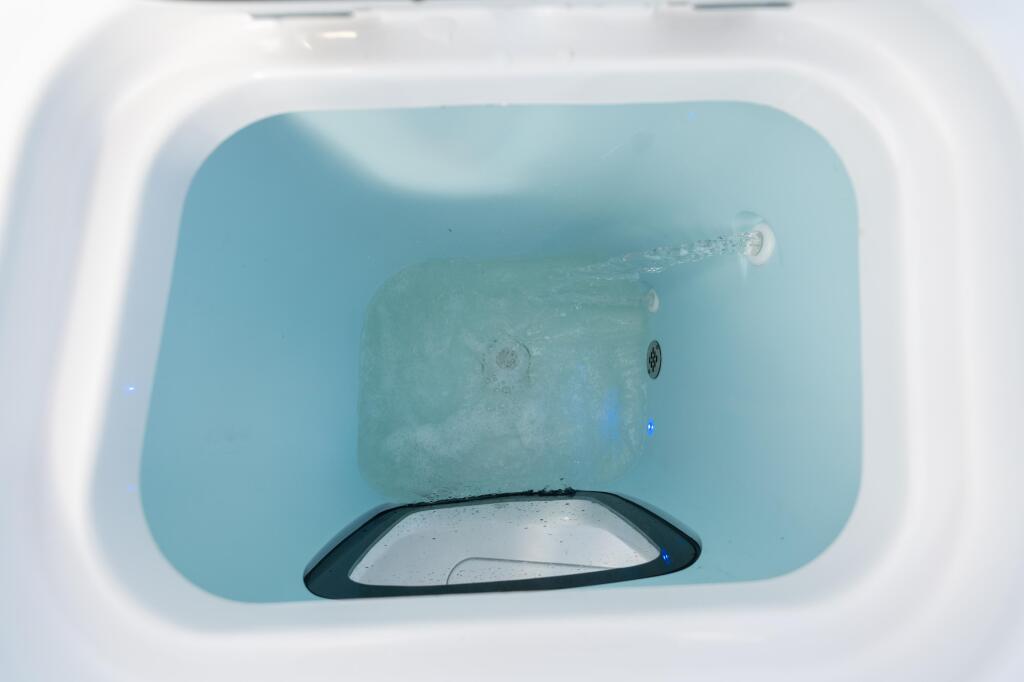 Livewell tank with aerated water and bait fish visible inside the white boat compartment