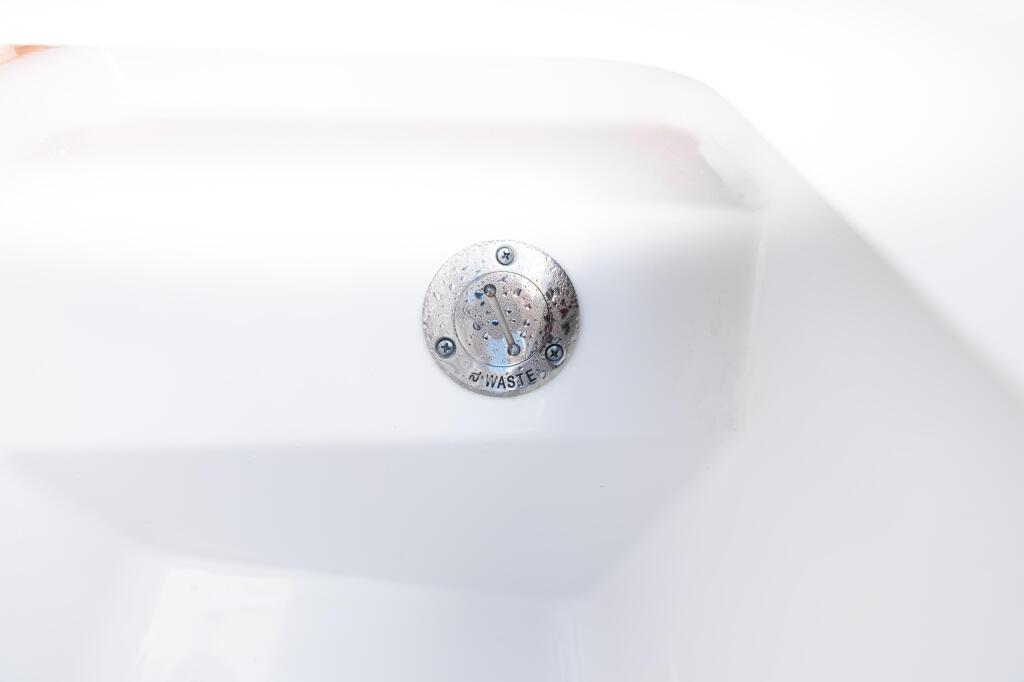 Waste pump-out fitting mounted on white fiberglass boat hull
