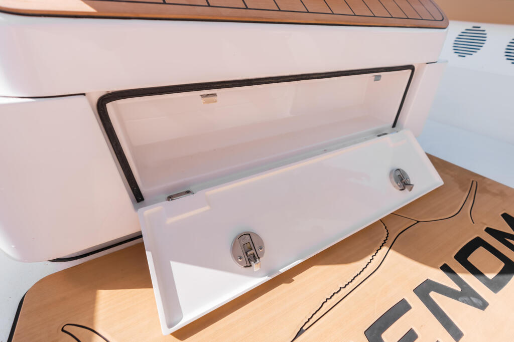 Open storage compartments with chrome handles integrated into the boat's console area