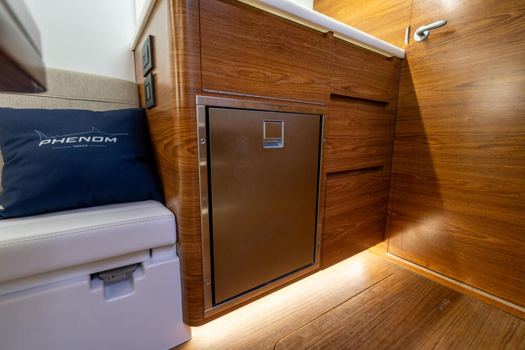 Cabin interior with wood paneling, refrigerator, seating, and ambient lighting