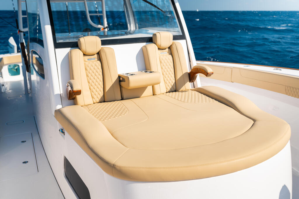 Cream-colored quilted seating with integrated armrests and backrests on a center console boat with open ocean in background