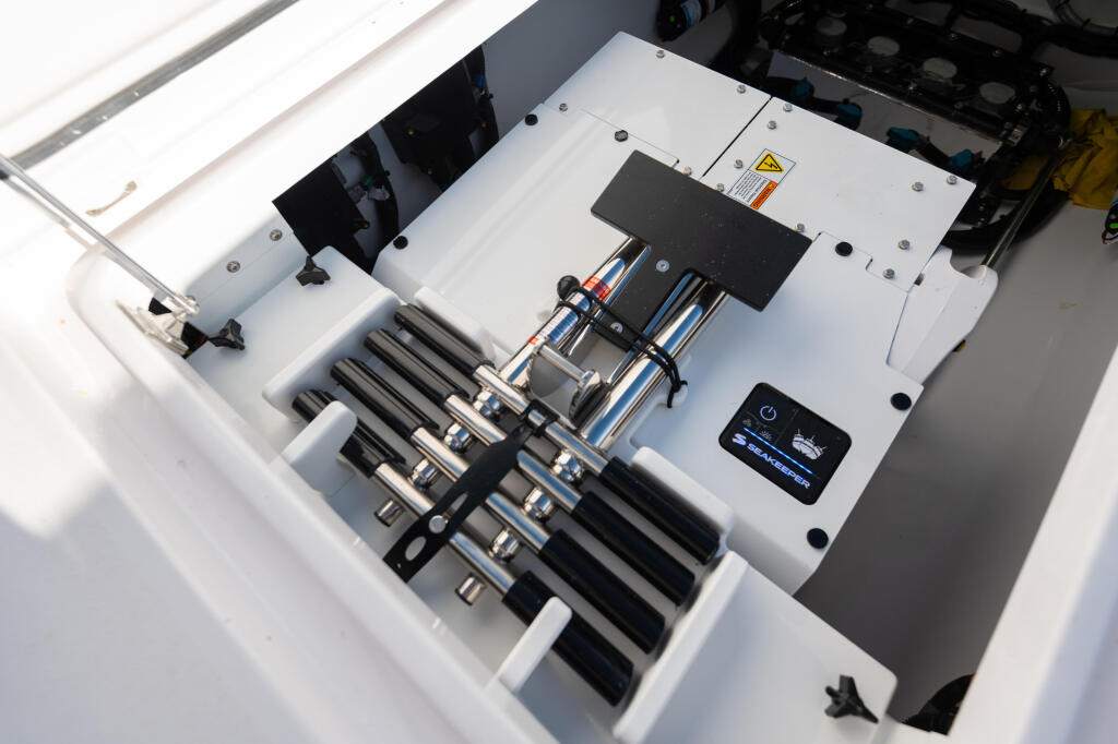 Overhead view of boat's electrical panel with multiple rod holders, control systems, and mounted electronics