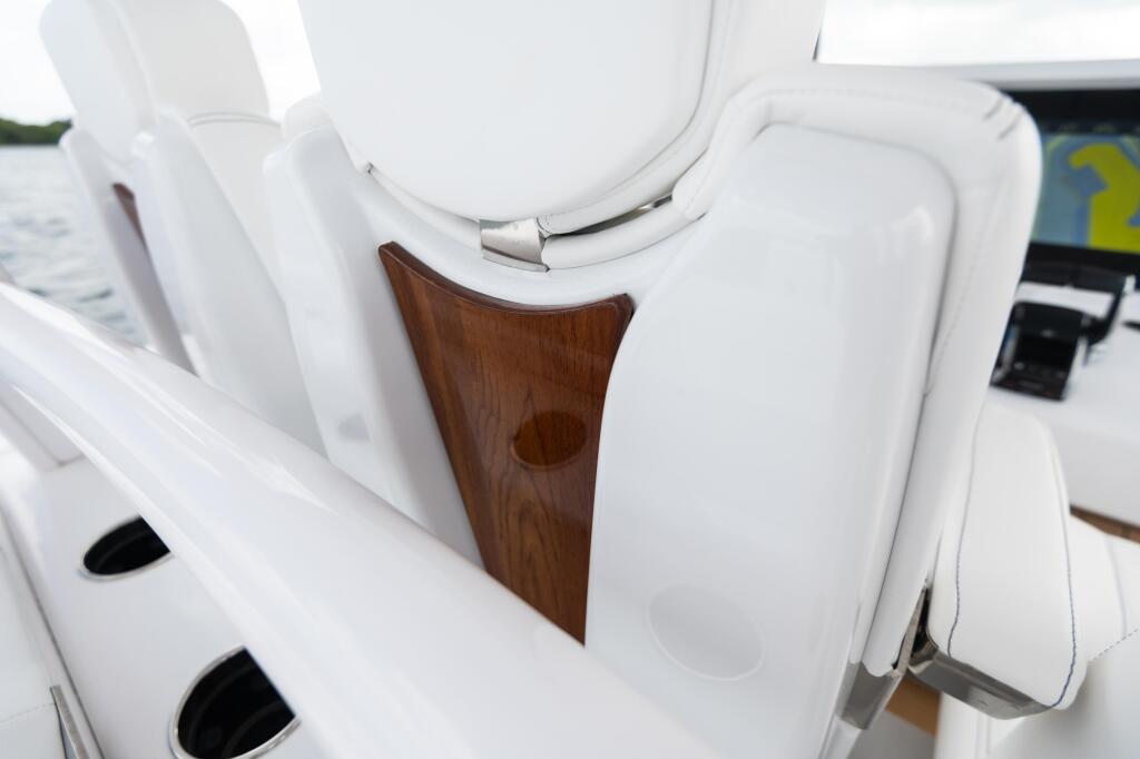 White leather helm seats with faux-teak accent panel and electronic controls visible at the helm station