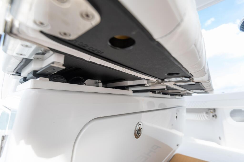 Helm chair with electric slide mechanism and control switches visible on boat interior