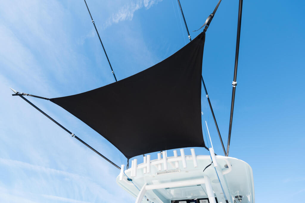 Black shade canopy stretched overhead on a boat's helm, providing sun protection against clear blue sky