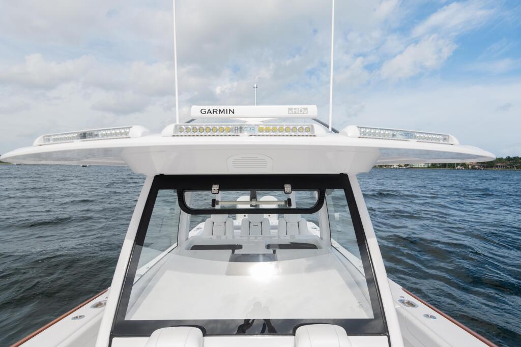 Center console fishing boat's helm with Garmin electronics, LED lighting, and windshield facing open water
