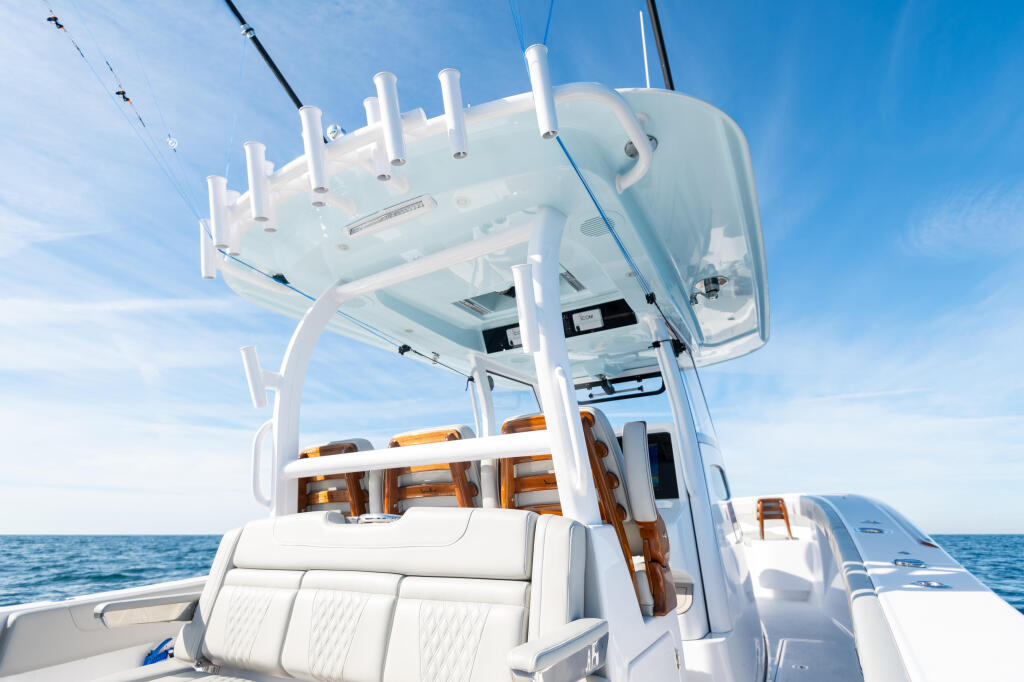 White fiberglass hard-top with D-tubing structure and white seating visible on a boat at sea
