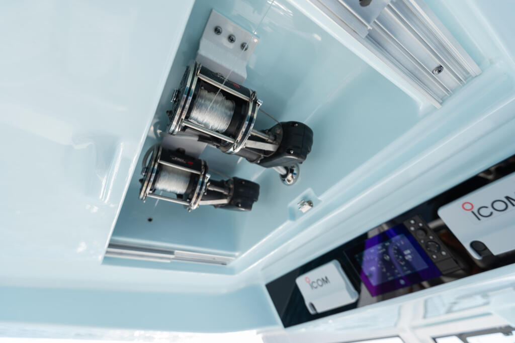 Mounted electric fishing reels and marine electronics installed in boat cabin ceiling