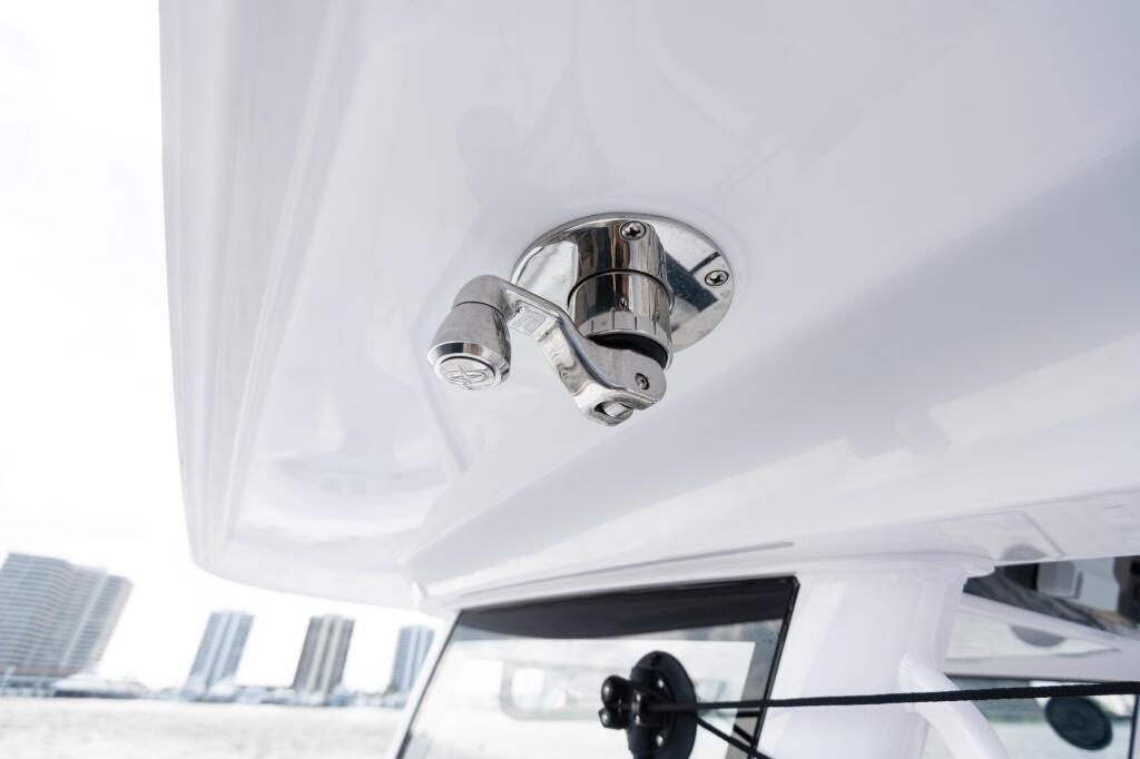 Polished chrome overhead light fixture mounted on white cabin ceiling of a boat