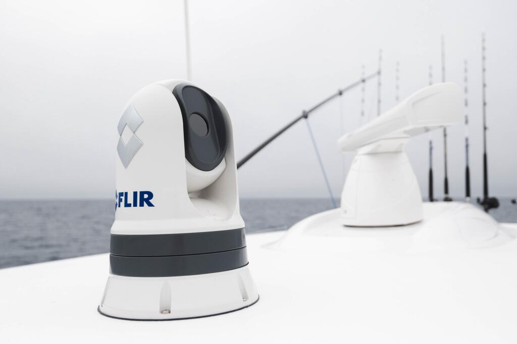 FLIR thermal camera mounted on boat helm with fishing rods visible in background