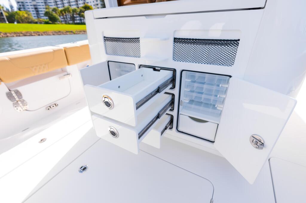 Boat tackle center with open drawers and storage compartments near the helm