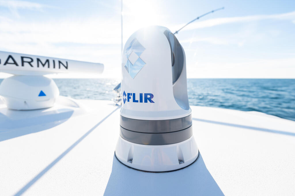 FLIR thermal camera mounted on boat helm with Garmin electronics visible offshore