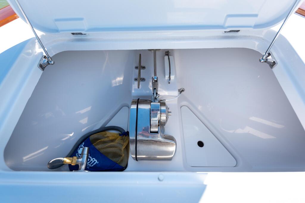 Open livewell compartment with aerator system and mesh bait bag inside light blue boat storage box