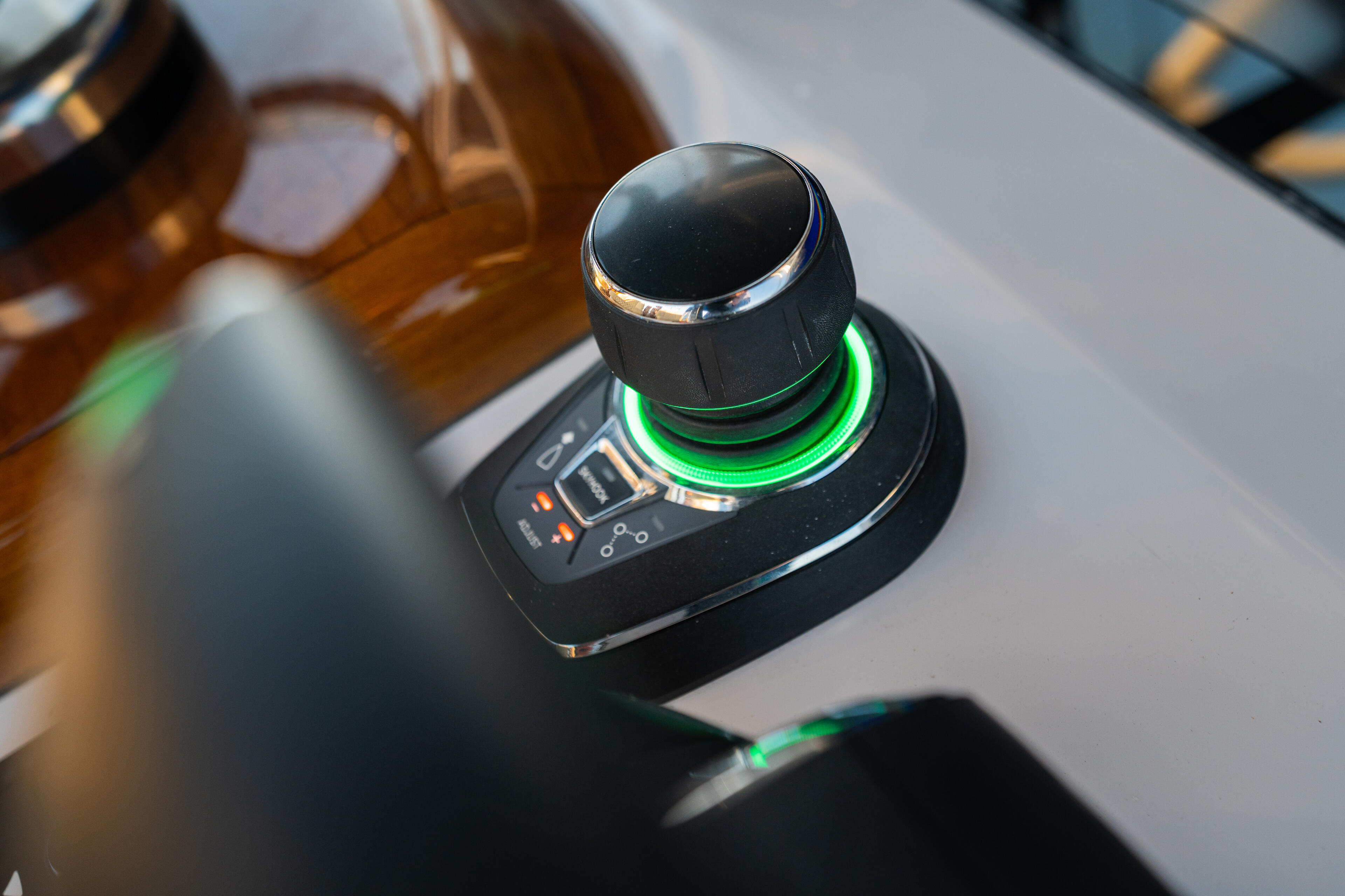 Illuminated boat throttle control with green LED ring on dashboard at helm