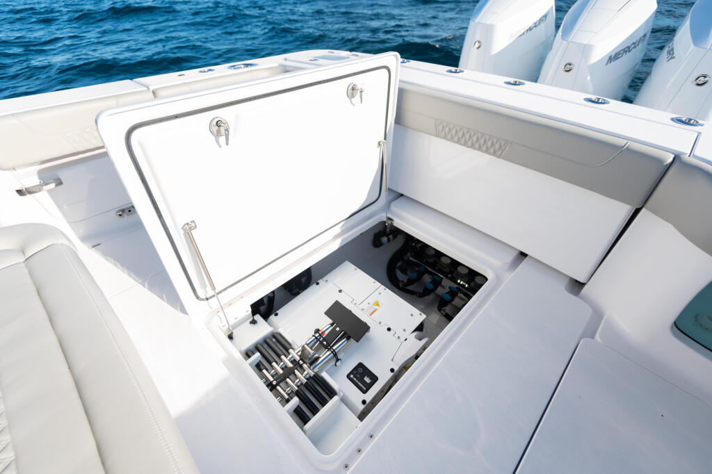 Open storage locker reveals Seakeeper gyroscopic stabilizer system with electronic controls and blue connectors