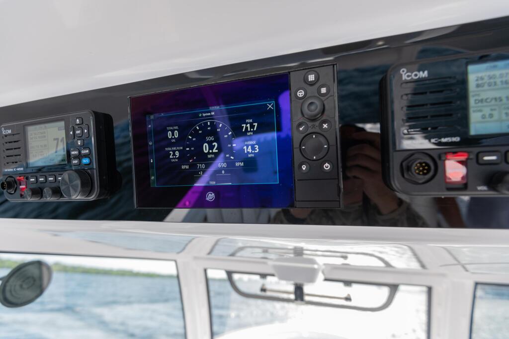 Helm display showing digital gauges and speed data on a touchscreen with marine electronics and controls